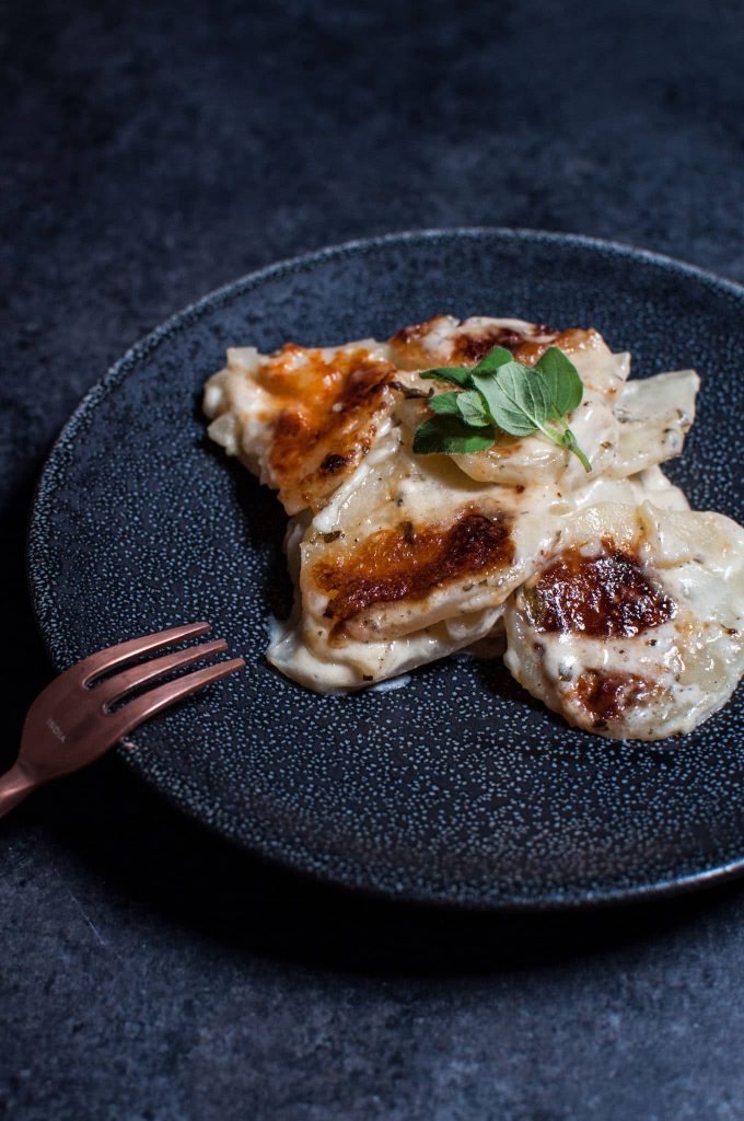 close-up of lemon and oregano potato gratin on a plate with a fork