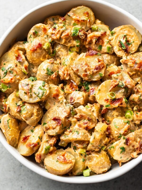 bacon potato salad in a white serving bowl