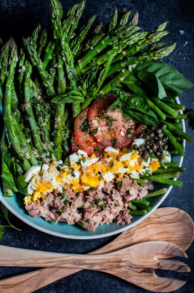 asparagus and green bean salad with tomatoes, tuna, and egg in a bowl
