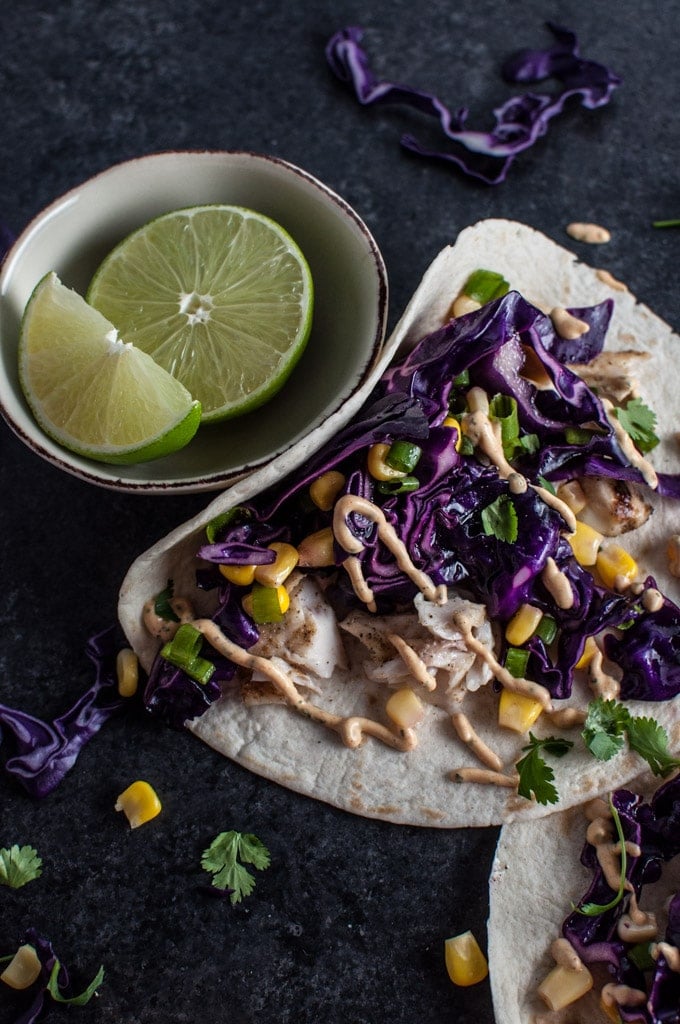 close-up of tilapia chipotle fish taco next to lime wedges