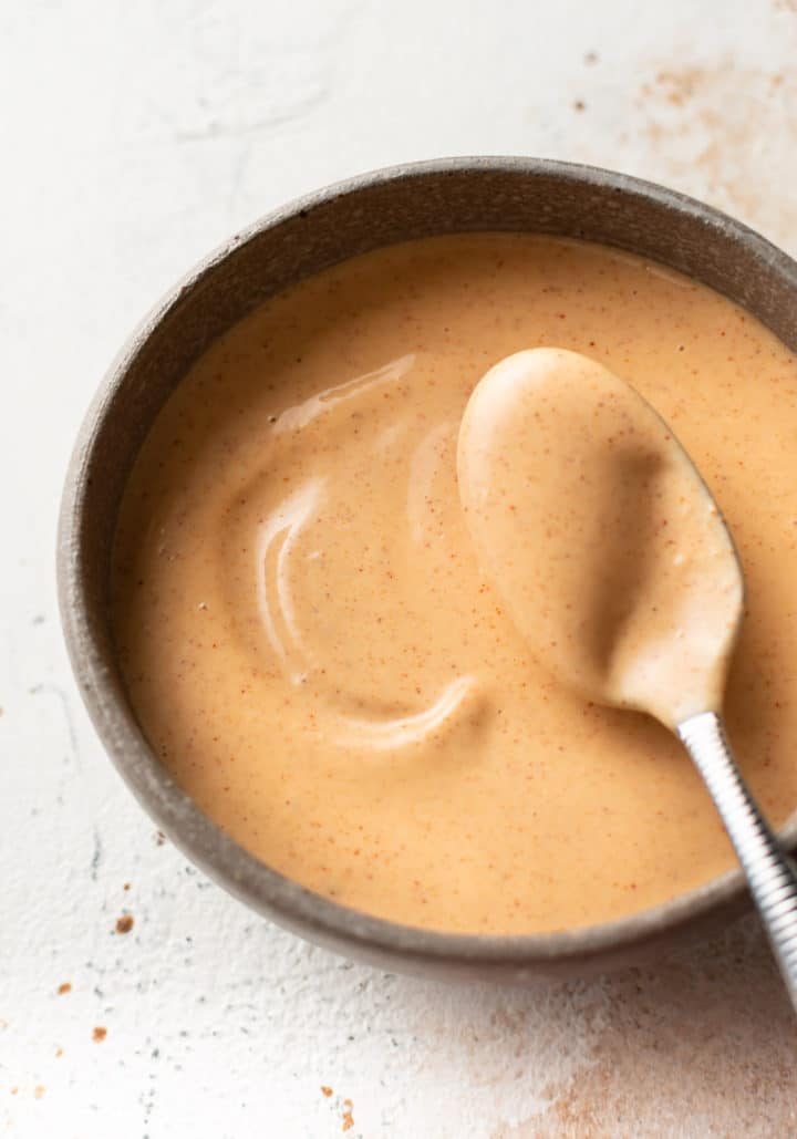 close-up of yum yum sauce in a small bowl with a spoon balanced over the bowl