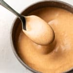 yum yum sauce in a small bowl with a drizzling spoonful of sauce