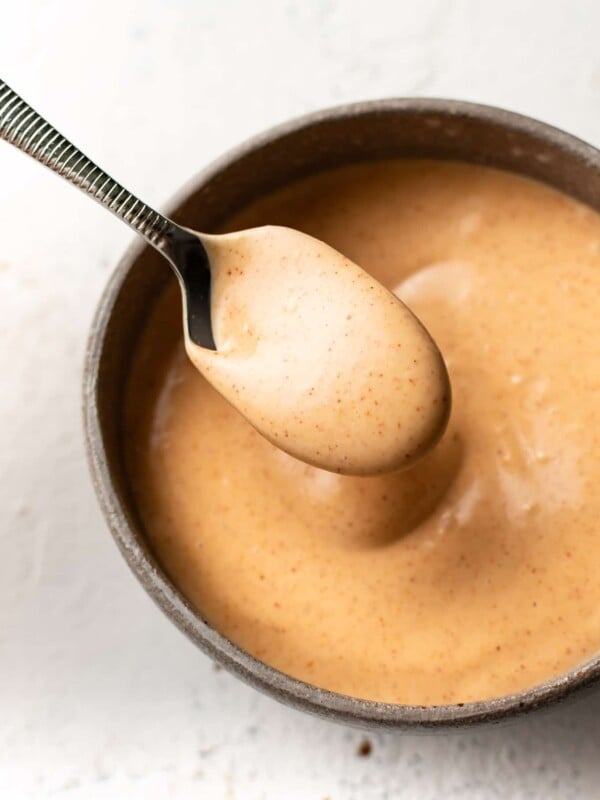 yum yum sauce in a small bowl with a drizzling spoonful of sauce