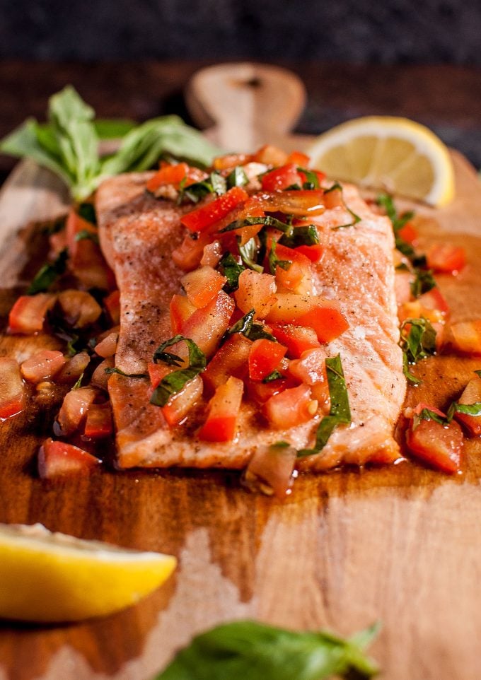 close-up of easy bruschetta salmon pomodoro with basil on a wooden board