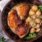 crispy lemon herb chicken with little potatoes in a brown bowl