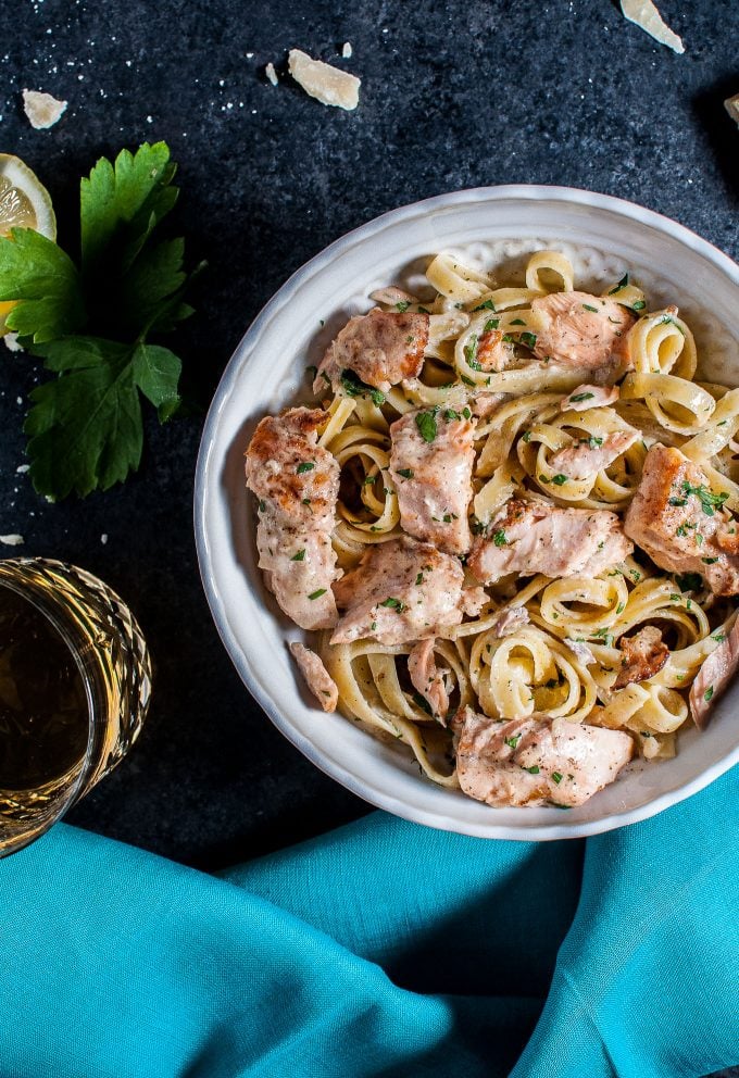 salmon pasta with a creamy garlic sauce in a white bowl