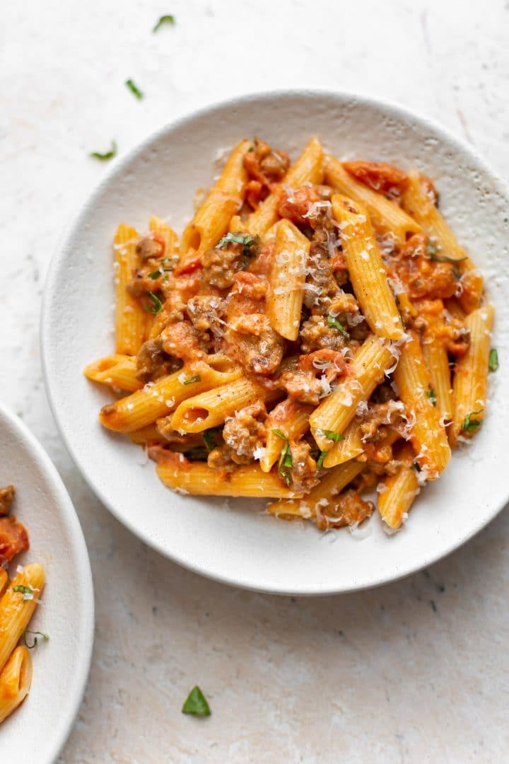 spicy Italian sausage and pasta in two white bowls