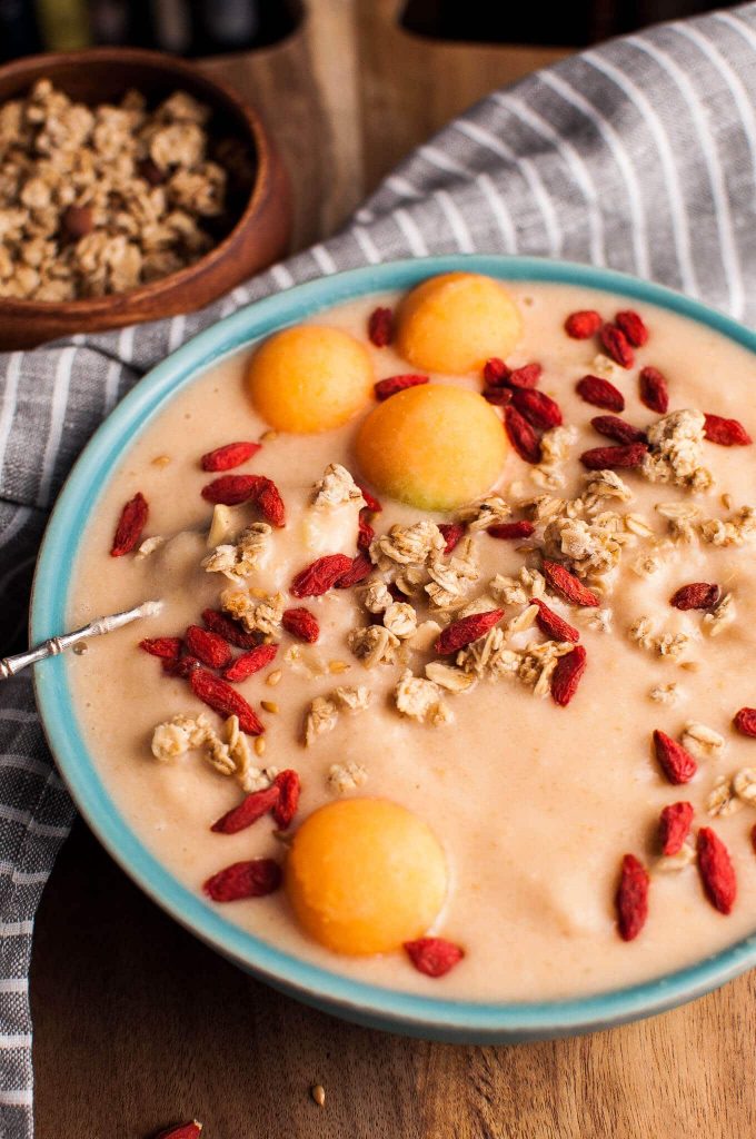 close-up with cantaloupe and banana smoothie bowl granola and dried goji berries