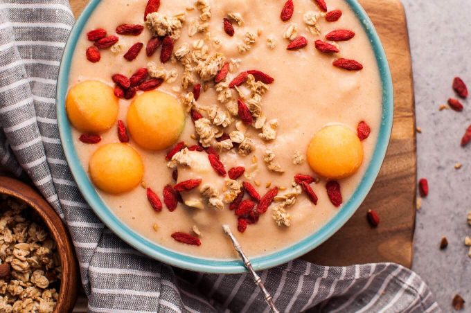 close-up of healthy cantaloupe melon and banana smoothie bowl with a spoon