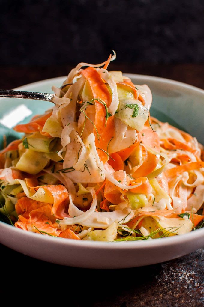 close-up of a fork with fennel, carrot, and zucchini salad