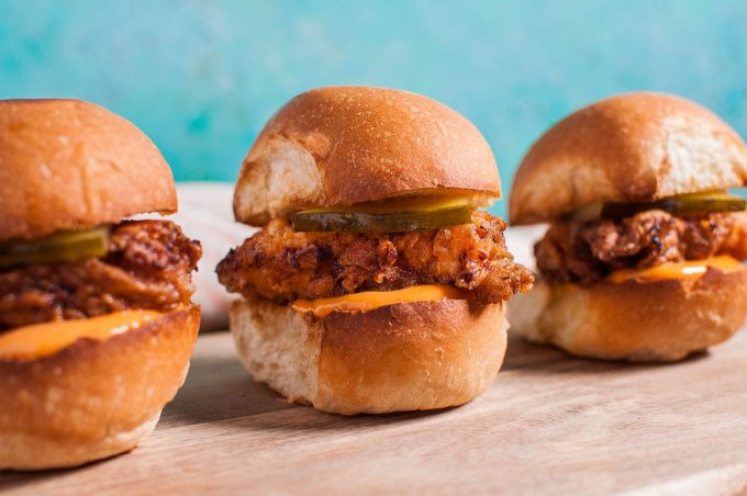 close-up of three fried chicken sliders with spicy mayo