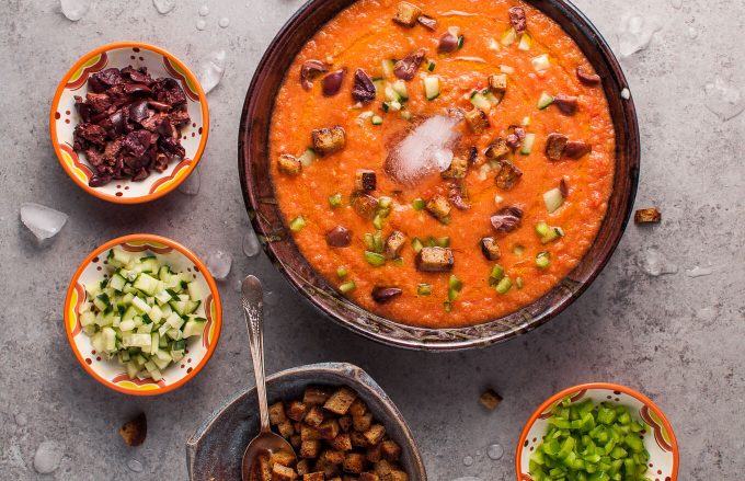 gazpacho soup with small bowls of croutons and soup toppings