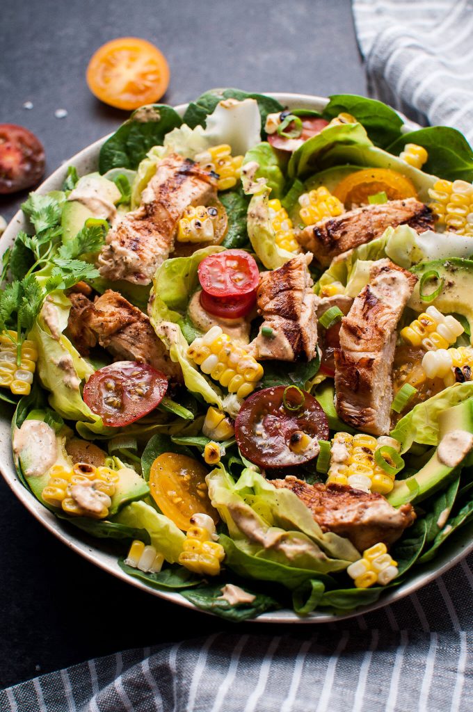close-up of bowl of grilled chicken salad with chipotle ranch dressing and vegetables