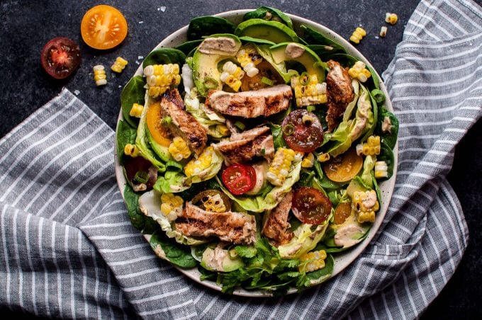 bowl with grilled chicken salad with corn, avocado, little tomatoes, and a chipotle ranch dressing