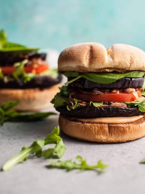 Devour these delicious veggie burgers with grilled portobello mushrooms and eggplant! Fried shallots, more fresh veggies, and a smoky mayo make this a healthier way to get your burger fix.