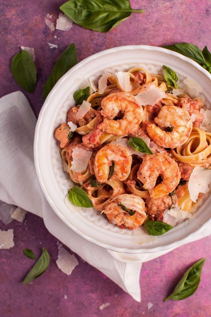 white bowl with shrimp pasta in a rosé sauce with grated parmesan