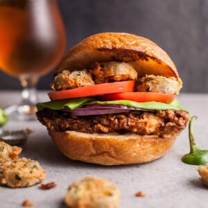My Southwest fried chicken sandwich with fried jalapenos is a chicken sandwich dream come true. The chipotle cilantro lime ranch sauce packs a ton of flavor. The buttermilk fried chicken is crispy on the outside and tender and juicy on the inside. Fried jalapenos add the kick. Fresh tomato, lettuce, and red onion top it off.