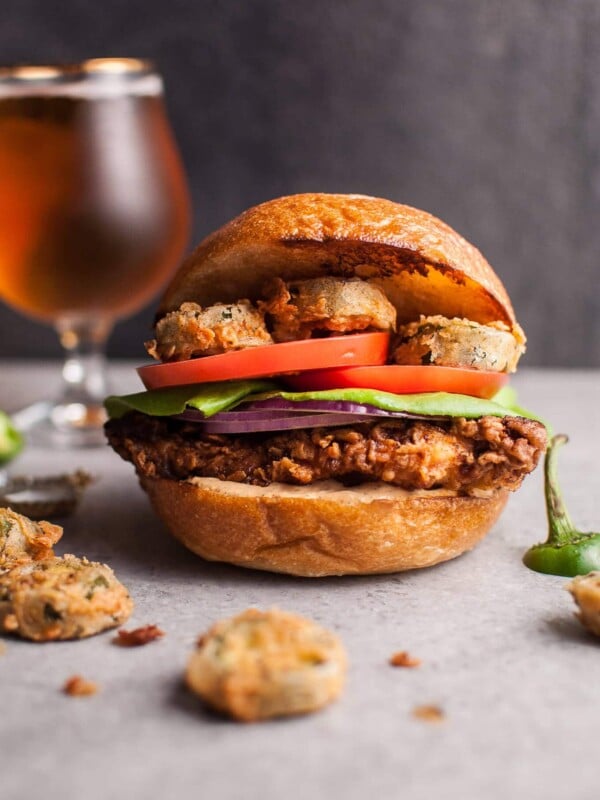 My Southwest fried chicken sandwich with fried jalapenos is a chicken sandwich dream come true. The chipotle cilantro lime ranch sauce packs a ton of flavor. The buttermilk fried chicken is crispy on the outside and tender and juicy on the inside. Fried jalapenos add the kick. Fresh tomato, lettuce, and red onion top it off.