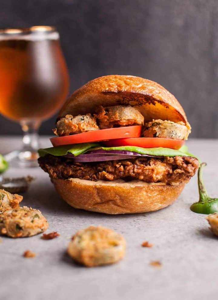 My Southwest fried chicken sandwich with fried jalapenos is a chicken sandwich dream come true. The chipotle cilantro lime ranch sauce packs a ton of flavor. The buttermilk fried chicken is crispy on the outside and tender and juicy on the inside. Fried jalapenos add the kick. Fresh tomato, lettuce, and red onion top it off.