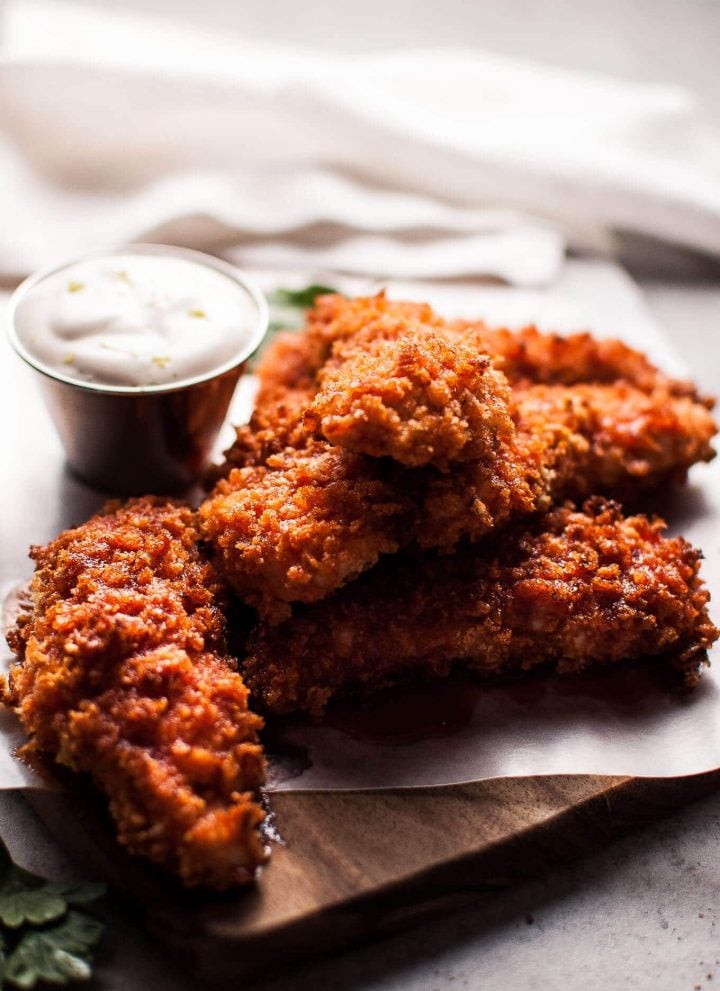 Sriracha honey chicken tenders are crunchy, spicy, sweet, and sticky. Served with a refreshing dipping sauce on the side!