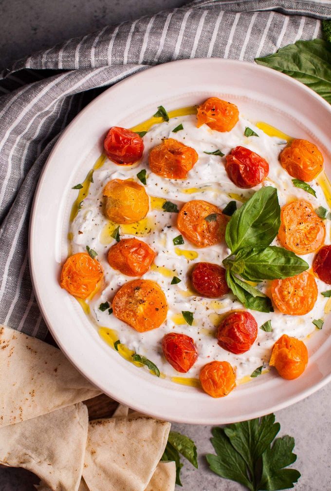 bowl of Greek yogurt dip with roasted tomatoes and fresh herbs