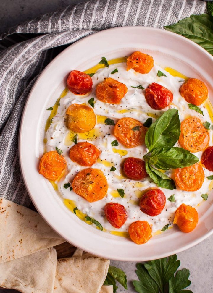 This summer Greek yogurt dip with roasted little tomatoes and fresh herbs makes a wonderful appetizer or snack! It's healthy, filling, and delicious.