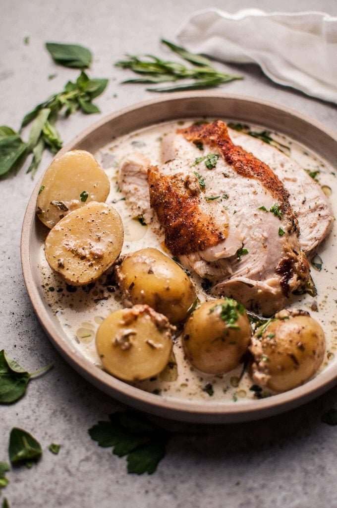 plate of creamy lemon and herb pot roasted chicken with little potatoes