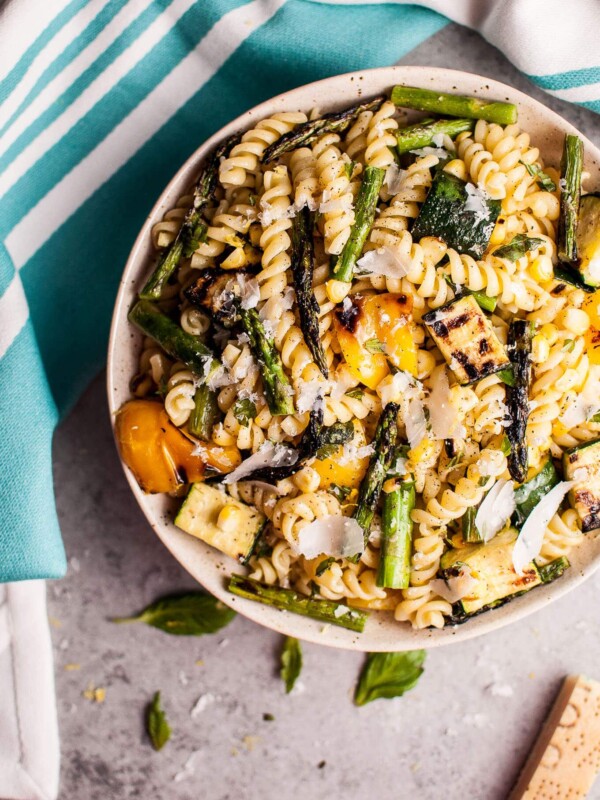 This grilled summer vegetable pasta salad is healthy and full of flavor! Zucchini, asparagus, corn, and yellow bell peppers are grilled to perfection and tossed with a fresh, lemony dressing. Easy to make and feeds a crowd!