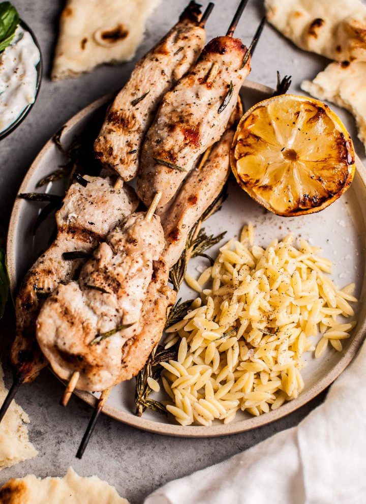 Juicy and flavorful rosemary chicken skewers are perfectly complemented with charred lemon and a delicious garlicky yogurt. Serve with orzo and naan, and you've got a fab feast on your hands.