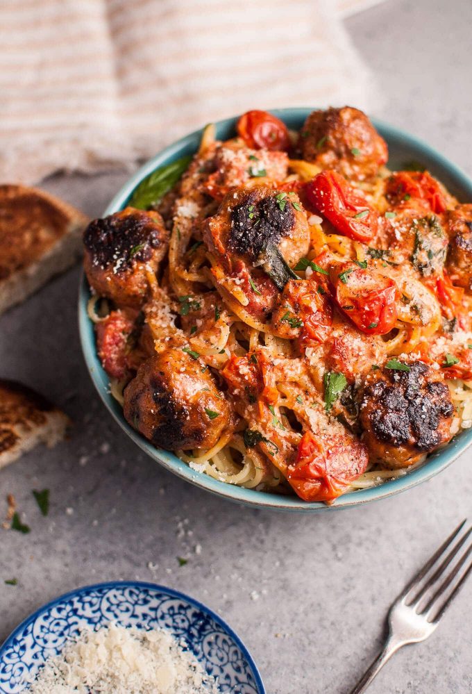 sausage meatballs and spaghetti with a roasted tomato, basil, and garlic cream sauce in a bowl