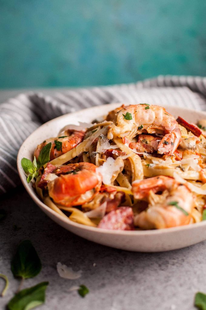 white bowl with creamy shrimp and chorizo pasta with mushrooms