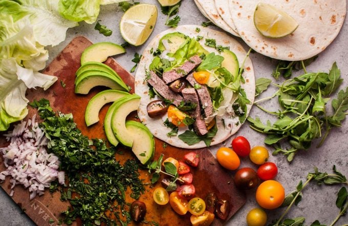 summer steak taco, fresh herbs, and vegetables on a cutting board