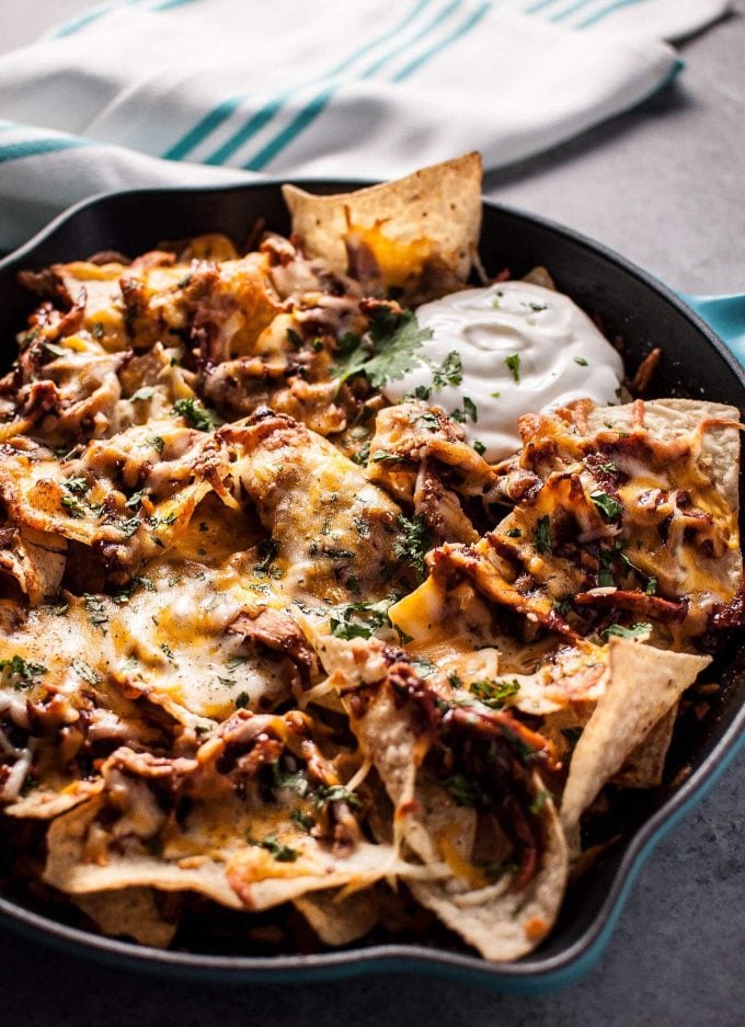 skillet with BBQ chicken nachos and sour cream