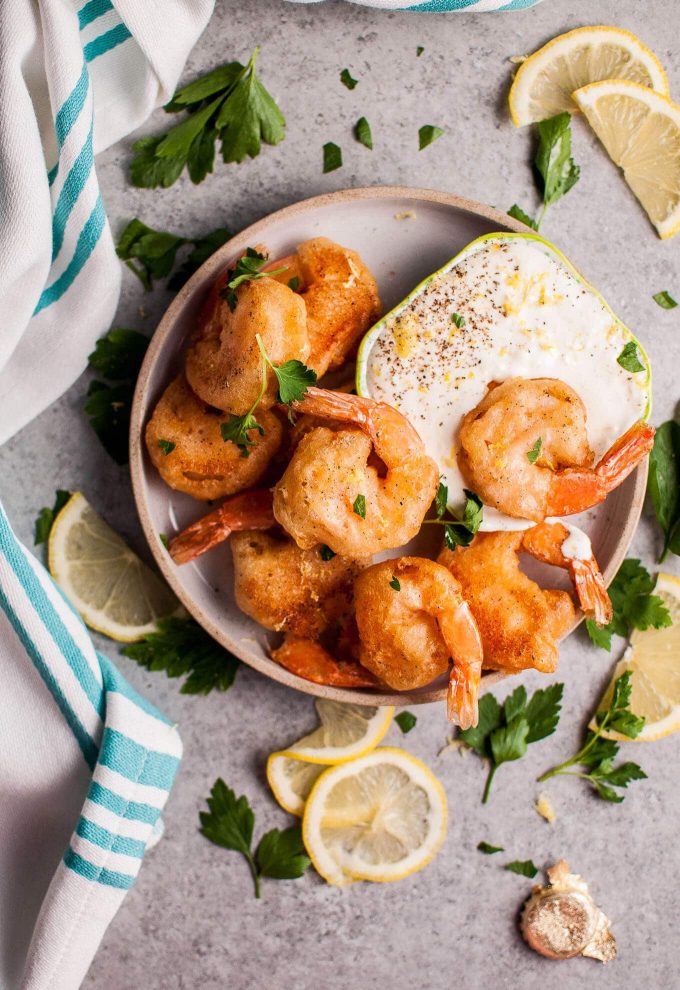 beer battered fried shrimp with homemade dipping sauce on a plate with lemon slices