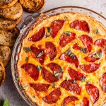 Chorizo pizza dip with garlic baguette slices for dipping... because all that cheese, garlic, and flavor just go so well together. This hot dip is easy to make and will please a hungry crowd!