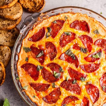 Chorizo pizza dip with garlic baguette slices for dipping... because all that cheese, garlic, and flavor just go so well together. This hot dip is easy to make and will please a hungry crowd!