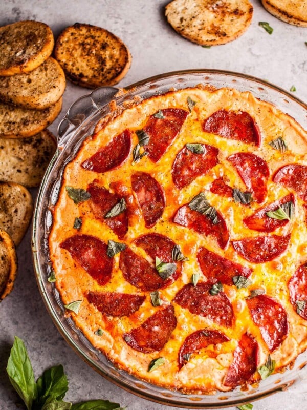 Chorizo pizza dip with garlic baguette slices for dipping... because all that cheese, garlic, and flavor just go so well together. This hot dip is easy to make and will please a hungry crowd!
