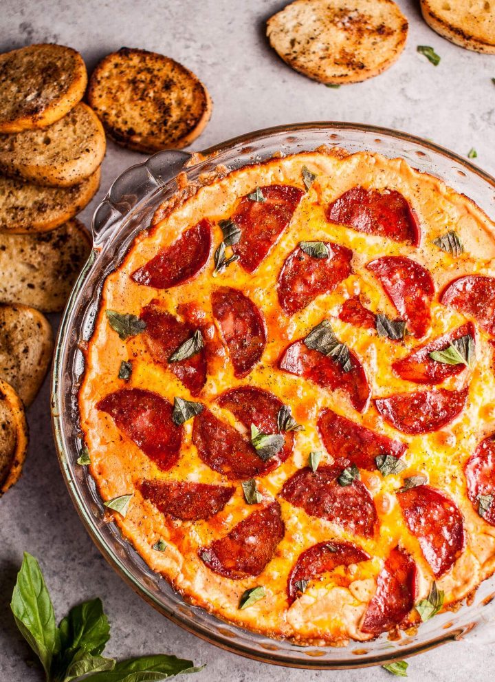 Chorizo pizza dip with garlic baguette slices for dipping... because all that cheese, garlic, and flavor just go so well together. This hot dip is easy to make and will please a hungry crowd!