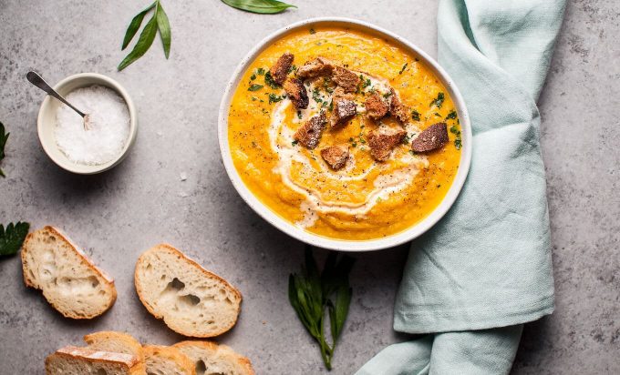 cauliflower and pumpkin soup with ginger next to slices of bread