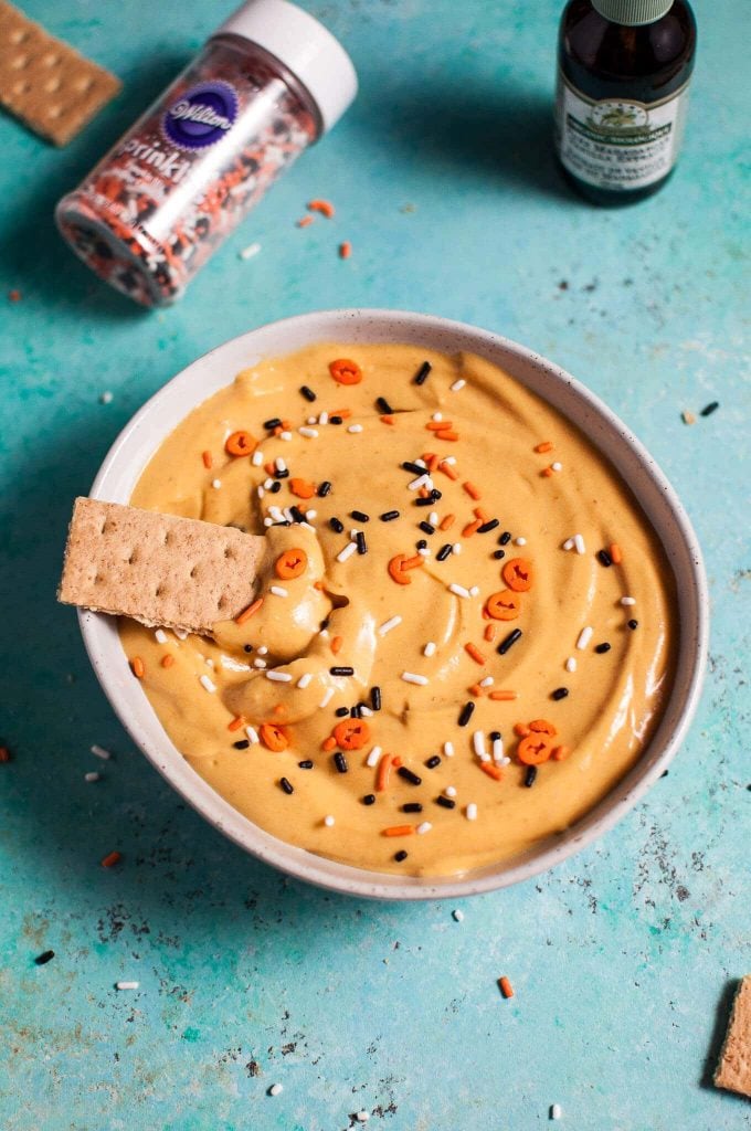 close-up of bowl of Halloween pumpkin cheesecake dip topped with orange and black sprinkles