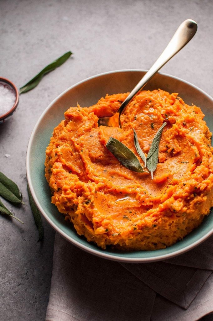 sage brown butter mashed sweet potatoes in a bowl with a spoon