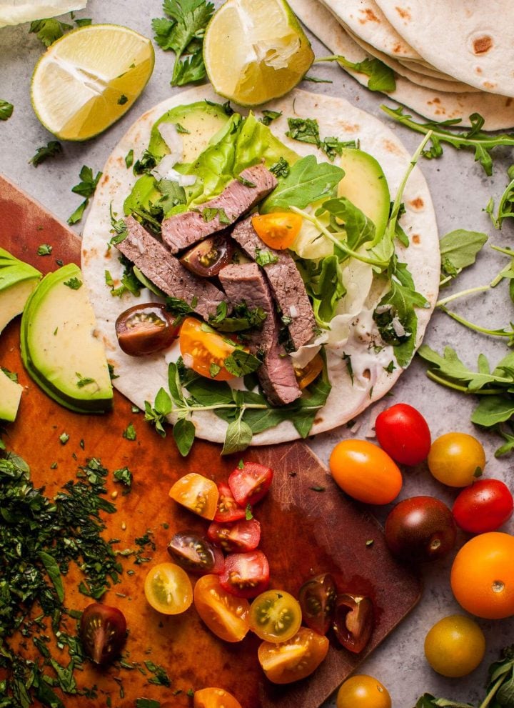 Summer steak tacos are easy, healthy, and full of flavor! Fresh oregano, parsley, cilantro, lime, and arugula kick up the taste in this 20 minute meal.
