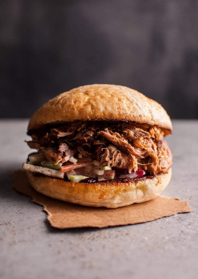 a close-up of a slow cooker pulled pork sandwich with crunchy apple slaw in a bun