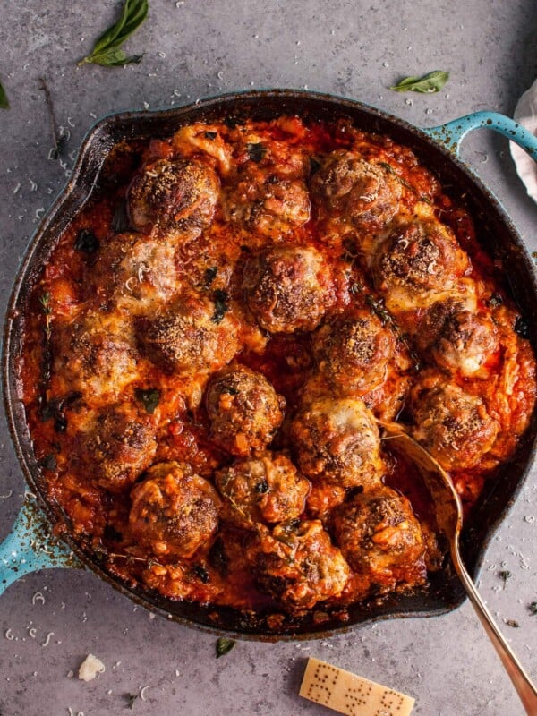 Hello cheesy baked meatball skillet of your dreams! Tender and flavorful meatballs, a rich tomato sauce, and plenty of melted cheese make this skillet recipe a winner.