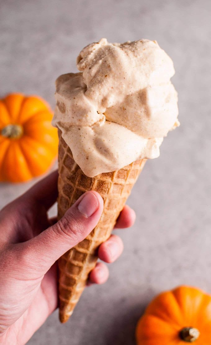 hand holding a cone of homemade cinnamon pumpkin ice cream
