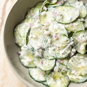 the BEST creamy cucumber salad (close-up in beige serving bowl)