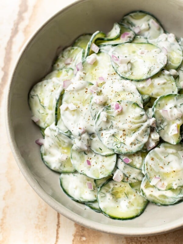 the BEST creamy cucumber salad (close-up in beige serving bowl)