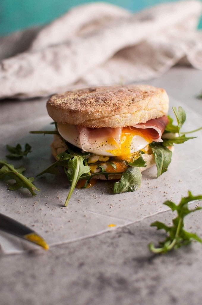 poached egg and prosciutto brunch sandwich beside a knife