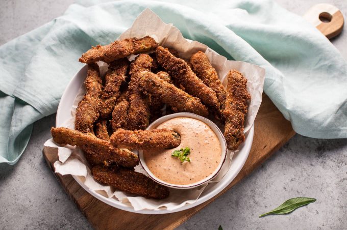 a bowl with homemade remoulade sauce and fried pickles