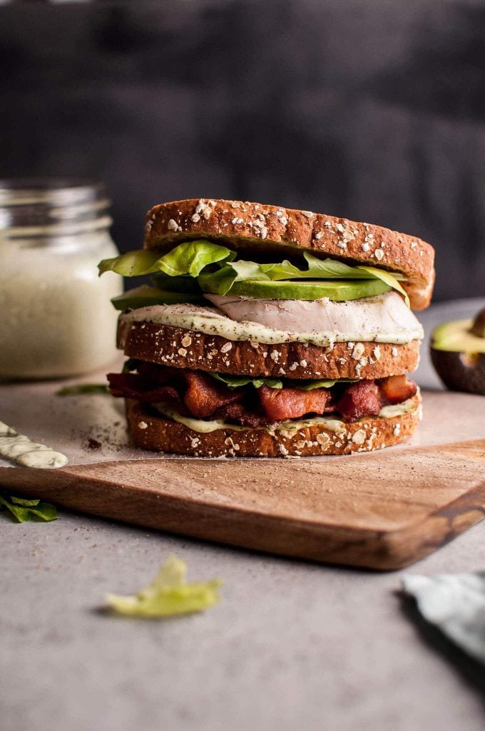 green goddess chicken sandwich on a wooden cutting board